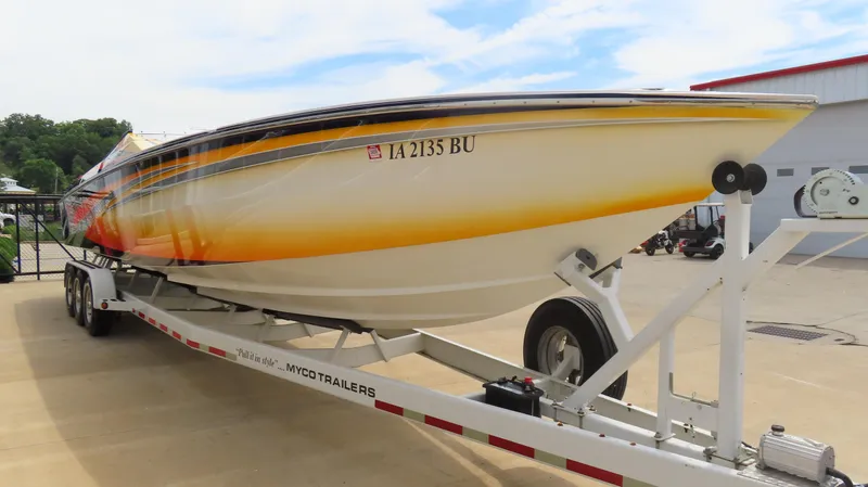Slide: The Image of 2005 Cigarette 38 Top Gun boat on trailer, vibrant yellow and orange design. - 2