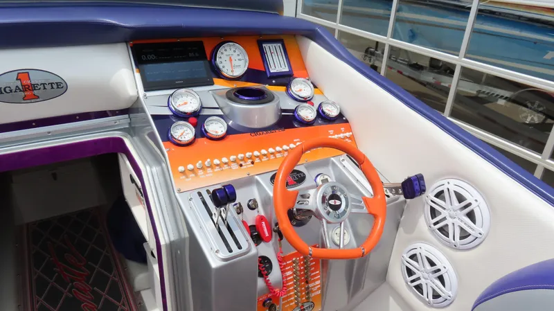 Slide: The Image of 2005 Cigarette 38 Top Gun boat dashboard with vibrant orange and purple accents. - 3