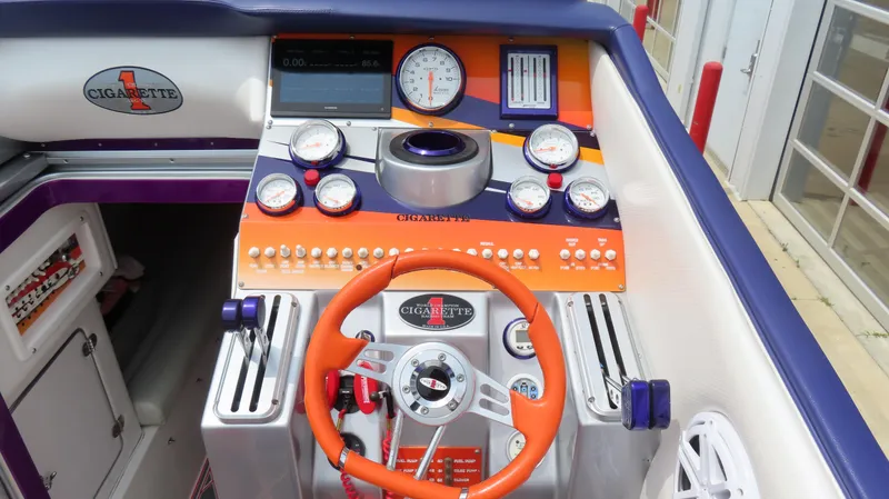 Slide: The Image of Dashboard of a 2005 Cigarette 38 Top Gun boat with orange steering wheel and gauges. - 4