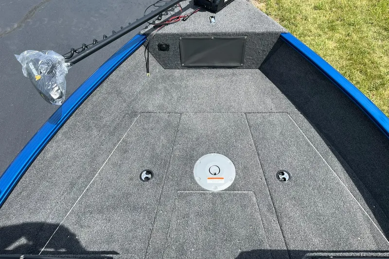 Slide: The Image of 2026 Lund 1775 Adventure Sport boat deck with gray carpeting and blue trim. - 11