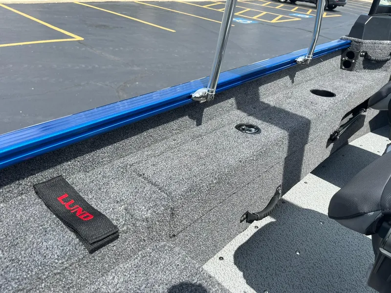 Slide: The Image of 2026 Lund 1775 Adventure Sport boat interior with gray carpet and blue trim. - 13