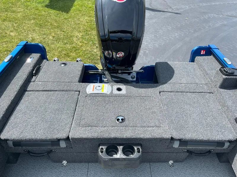 Slide: The Image of 2026 Lund 1775 Adventure Sport boat interior with motor, gray carpet, and storage compartments. - 14