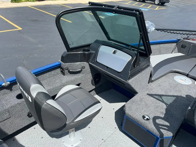 Slide: The Image of 2026 Lund 1775 Adventure Sport boat interior with seating and windshield in a parking lot. - 8