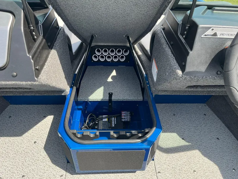 Slide: The Image of 2026 Lund 1775 Adventure Sport boat interior storage compartment with rod holders and battery charger. - 9
