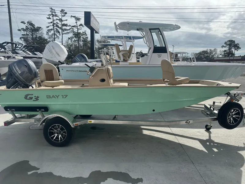 Slide: The Image of 2024 G3 Bay 17 boat on trailer, displayed outdoors with other boats. - 3