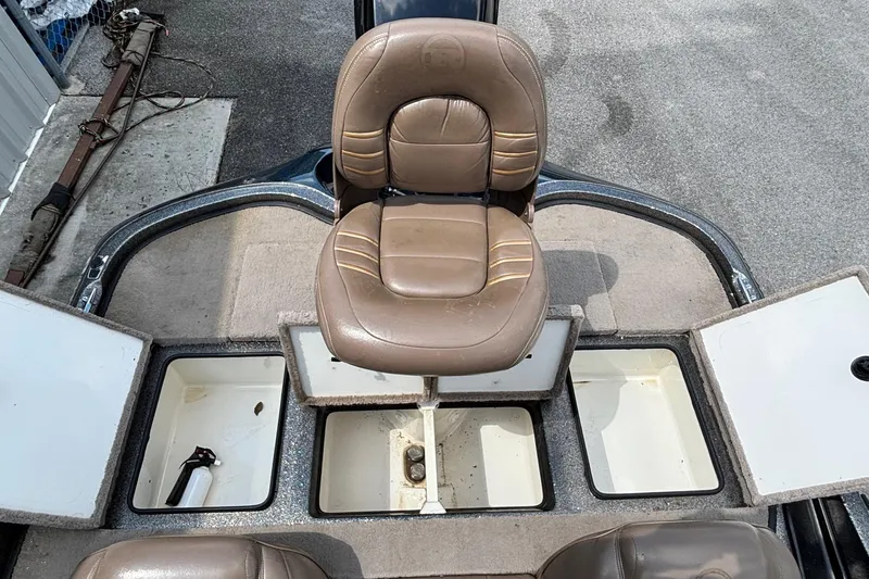 Slide: The Image of 2000 Ranger 518VX Comanche boat interior with brown seat and storage compartments. - 13