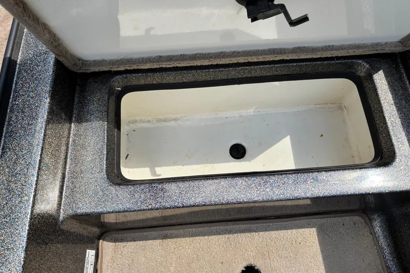 Slide: The Image of Open storage compartment in a 2000 Ranger 518VX Comanche boat, showing interior details. - 8