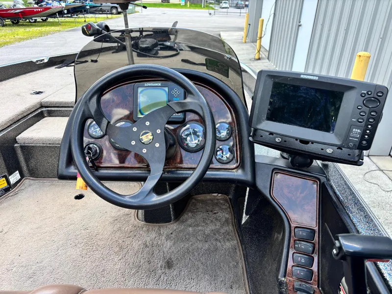 Slide: The Image of 2000 Ranger 518VX Comanche boat dashboard with steering wheel and electronic display. - 9