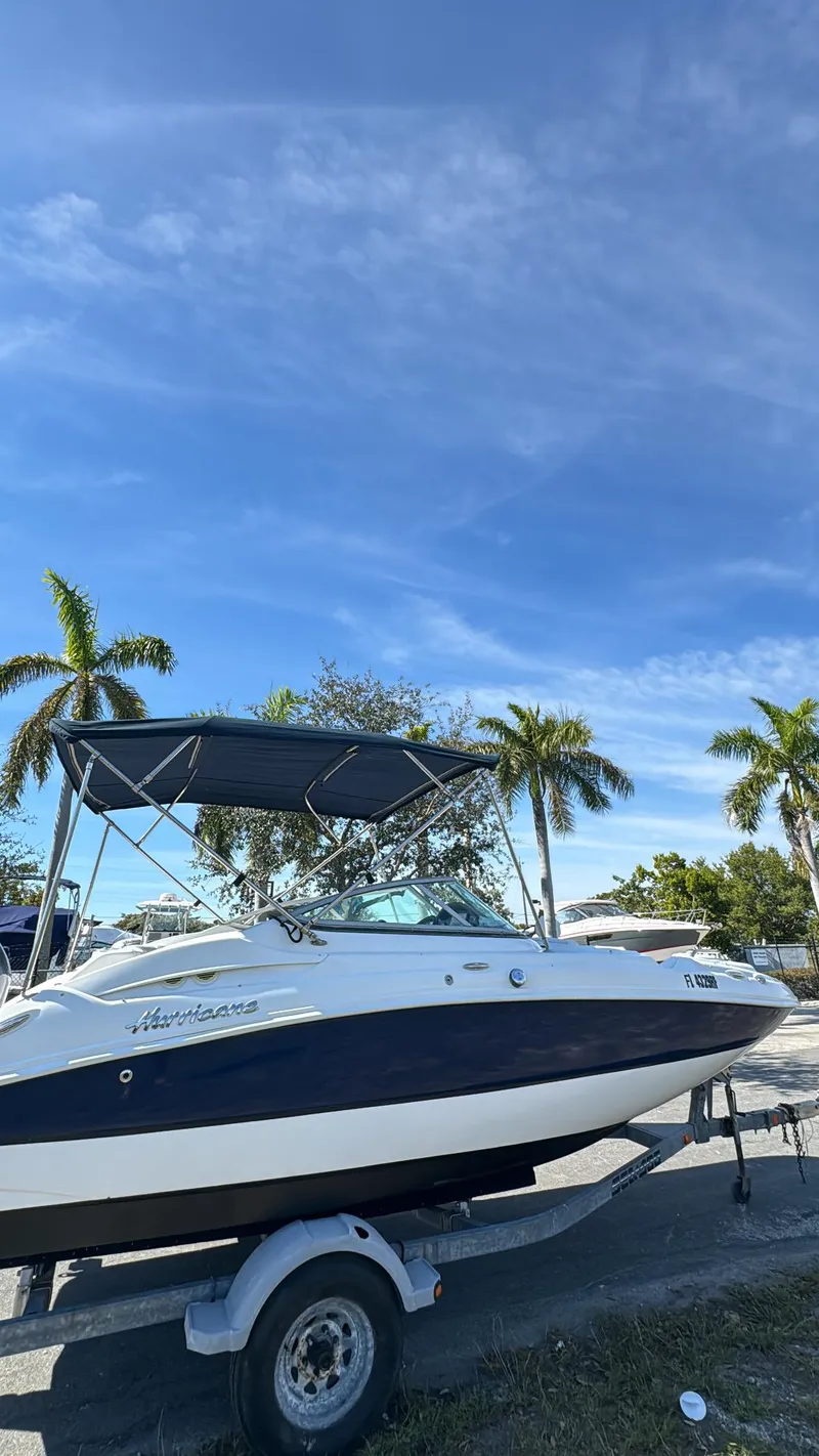 Slide: The Image of 2017 Hurricane 2000SD boat on trailer with palm trees and blue sky background. - 10
