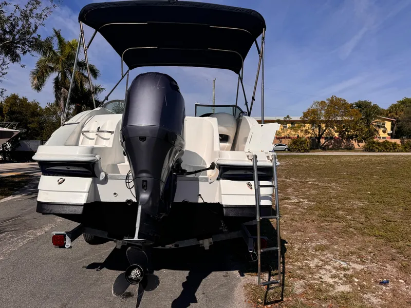 Slide: The Image of 2017 Hurricane 2000SD boat with outboard motor and canopy, parked on grass. - 12