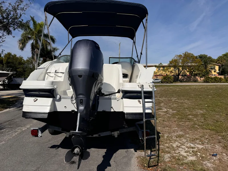 Slide: The Image of 2017 Hurricane 2000SD boat with outboard motor and canopy, parked on grass. - 13