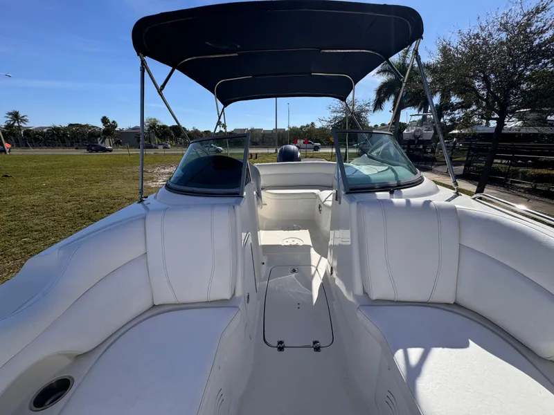 Slide: The Image of 2017 Hurricane 2000SD boat with white seating and canopy, parked outdoors. - 32
