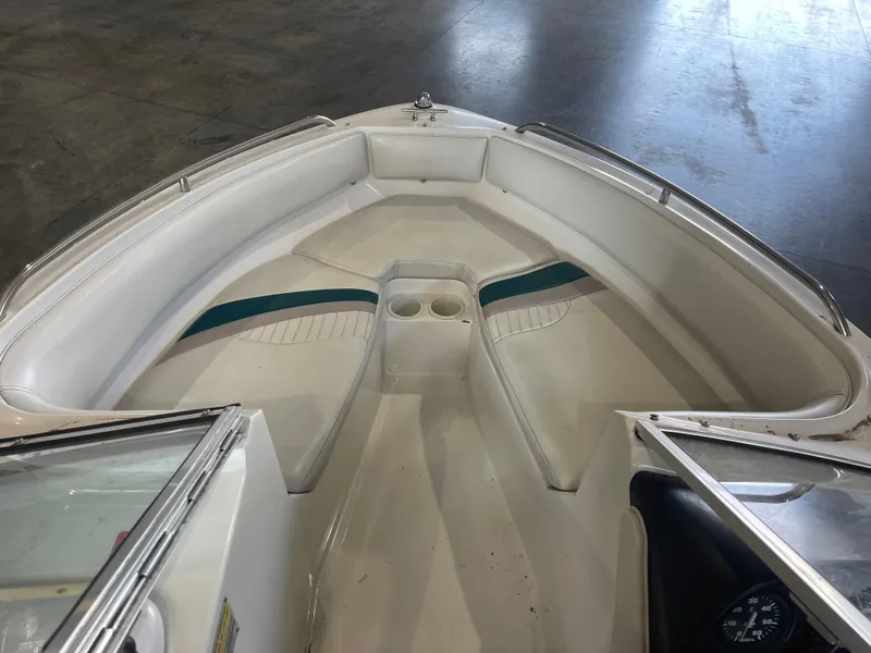 Slide: The Image of Interior view of a 1993 Regal 176 SE boat with white seating and teal accents. - 13