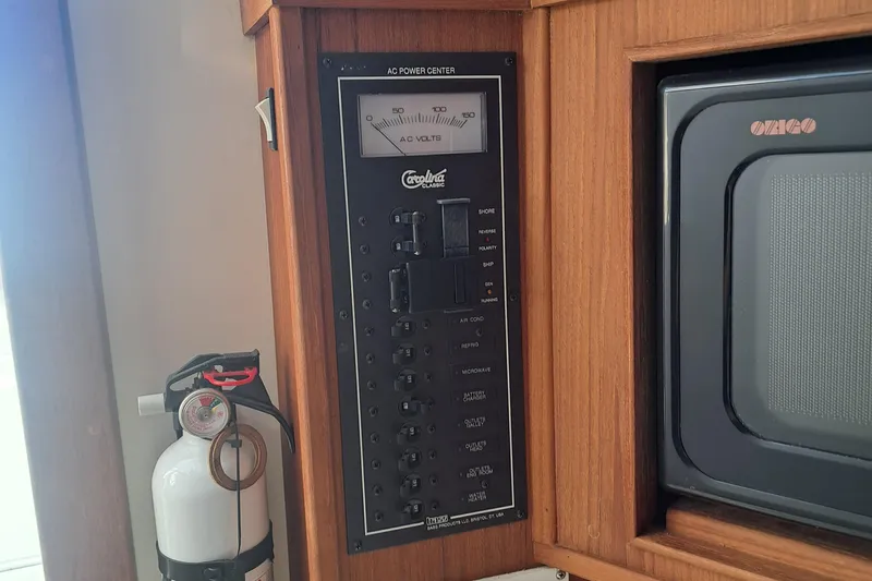 Slide: The Image of 2003 Carolina Classic 28 Express Sportfisherman AC power center and fire extinguisher. - 14