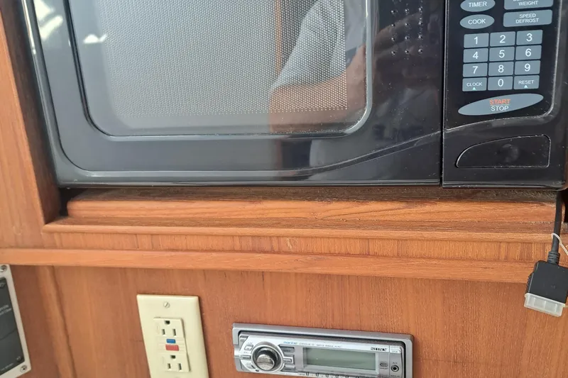 Slide: The Image of Microwave and stereo in 2003 Carolina Classic 28 Express Sportfisherman interior. - 15