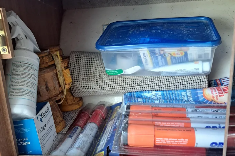 Slide: The Image of Storage compartment with safety gear and supplies on a 2003 Carolina Classic 28 Express Sportfisherman. - 17