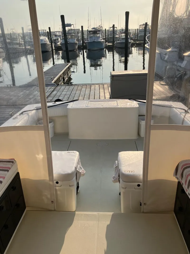 Slide: The Image of 2003 Carolina Classic 28 Express Sportfisherman at marina, interior view with seating and dock. - 4