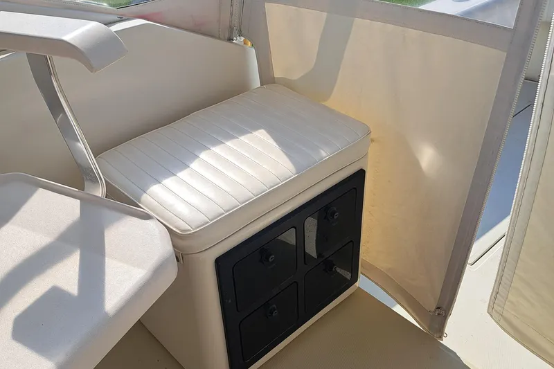 Slide: The Image of 2003 Carolina Classic 28 Express Sportfisherman interior with cushioned seating and storage compartments. - 5
