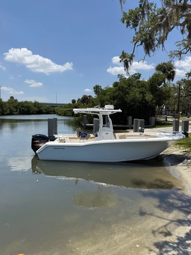 Slide: The Image of 2016 Tidewater 230 CC Adventure boat docked by a scenic waterway. - 17