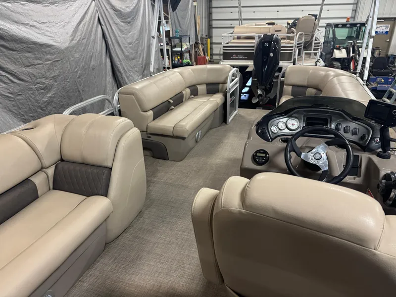 Slide: The Image of 2021 Sun Tracker Party Barge 20 DLX interior with beige seating and steering console. - 6