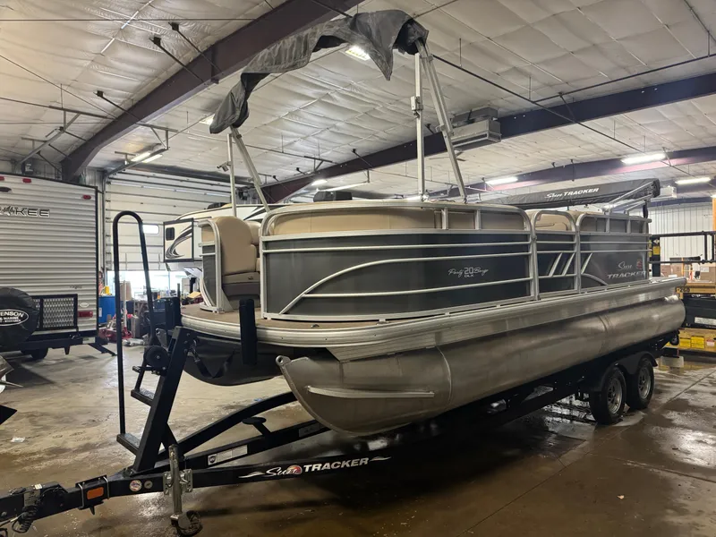 The Image of 2021 Sun Tracker Party Barge 20 DLX pontoon boat on trailer in indoor storage. - 1