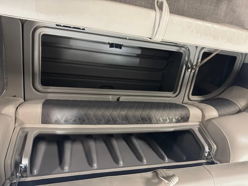 Slide: The Image of 2021 Sun Tracker Party Barge 20 DLX storage compartment with cushioned seating and open hatch. - 13