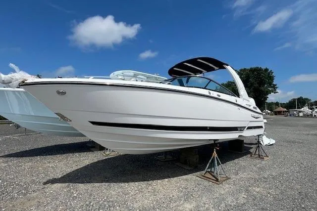 The Image of 2026 Monterey 275 Super Sport boat on stands under a clear blue sky. - 1