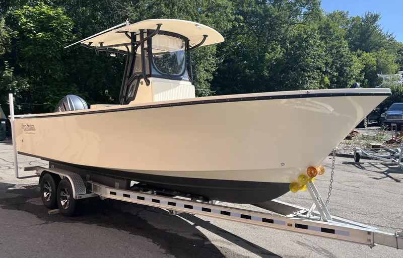 Slide: The Image of 2024 Jones Brothers Cape Fisherman 26 Light Tackle boat on trailer, outdoors. - 13