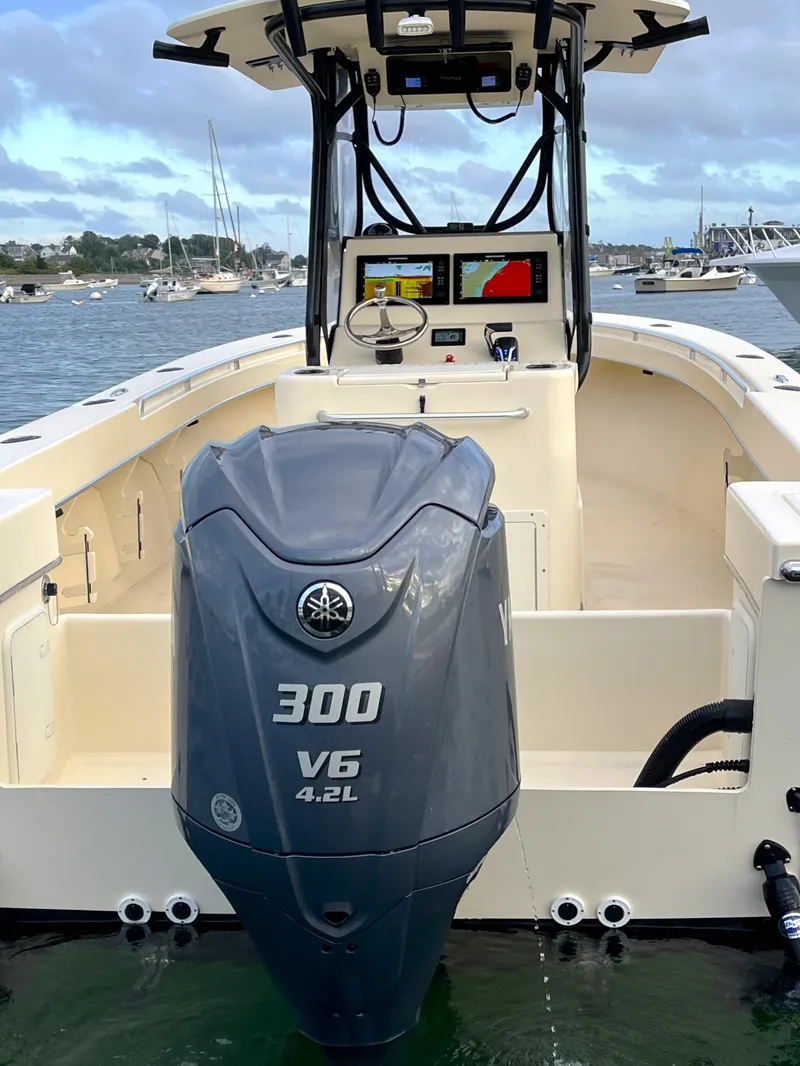Slide: The Image of 2024 Jones Brothers Cape Fisherman 26 with Yamaha 300 V6 engine on calm water. - 2