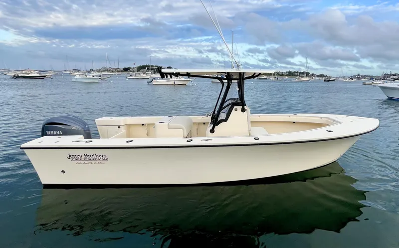 Slide: The Image of 2024 Jones Brothers Cape Fisherman 26 Light Tackle boat on calm water. - 3