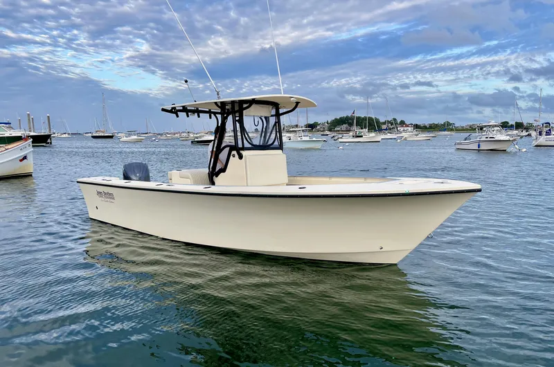 The Image of 2024 Jones Brothers Cape Fisherman 26 Light Tackle boat on calm water under cloudy sky. - 0