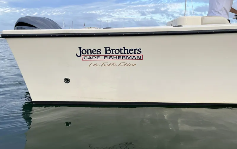 Slide: The Image of 2024 Jones Brothers Cape Fisherman 26 Light Tackle boat on water, side view. - 1