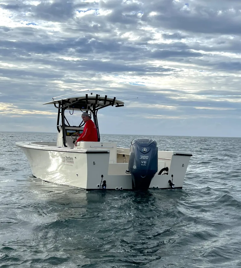Slide: The Image of 2024 Jones Brothers Cape Fisherman 26 Light Tackle boat on open water under cloudy sky. - 10