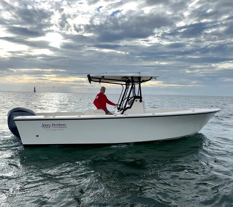 Slide: The Image of 2024 Jones Brothers Cape Fisherman 26 Light Tackle boat on open water under cloudy sky. - 11
