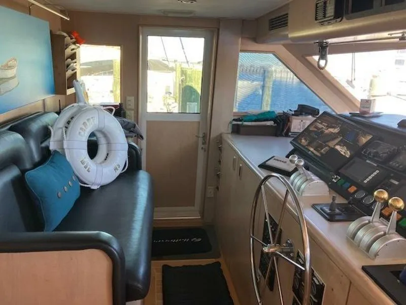 Slide: The Image of 1996 Hatteras 70 Sport Deck Motor Yacht interior with helm, seating, and nautical decor. - 29