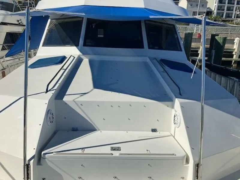 Slide: The Image of 1996 Hatteras 70 Sport Deck Motor Yacht with blue canopy, docked at marina. - 10