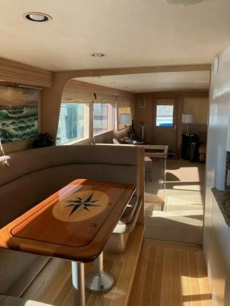 Slide: The Image of Interior of 1996 Hatteras 70 Sport Deck Motor Yacht with elegant dining area and natural light. - 17