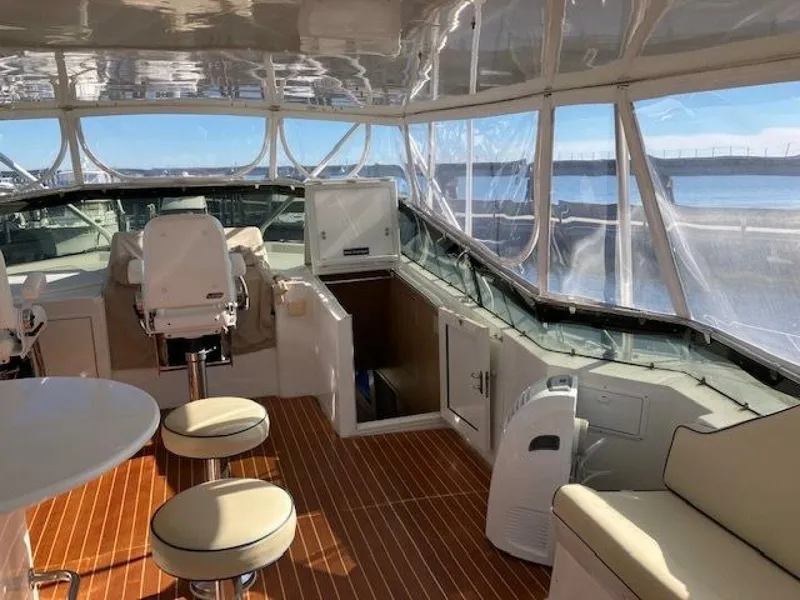 Slide: The Image of 1996 Hatteras 70 Sport Deck Motor Yacht interior with seating and helm, overlooking the ocean. - 8