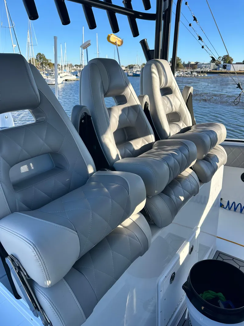 Slide: The Image of Luxurious seating on a 2024 Wyatt and Freeman 42LR boat, docked at a marina. - 11