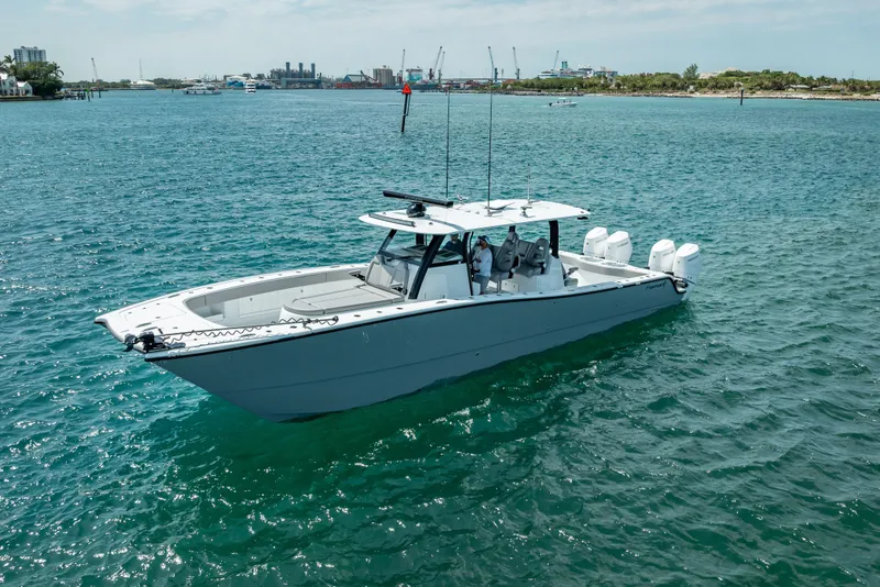 Slide: The Image of 2024 Freeman 42LR boat on open water, featuring sleek design and multiple engines. - 2