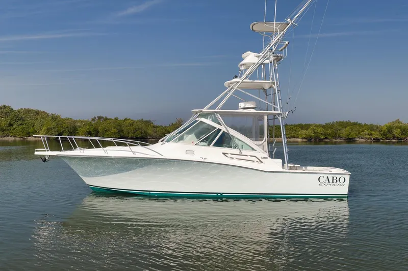 Slide: The Image of 2006 Cabo 32 Express boat on calm water with clear sky background. - 14
