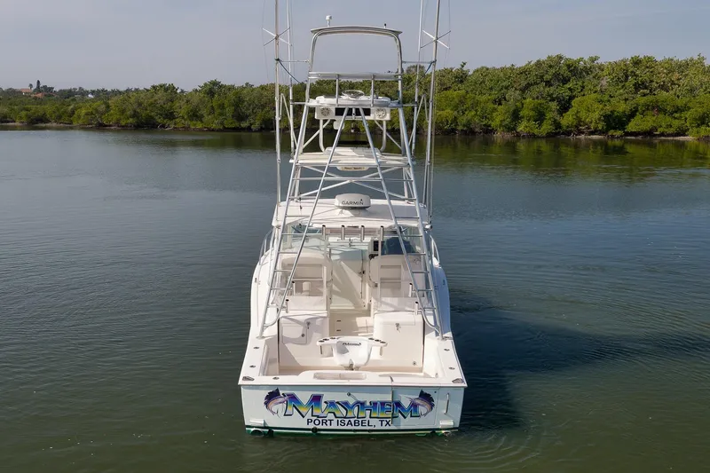 Slide: The Image of 2006 Cabo 32 Express boat on calm water near lush greenery. - 9