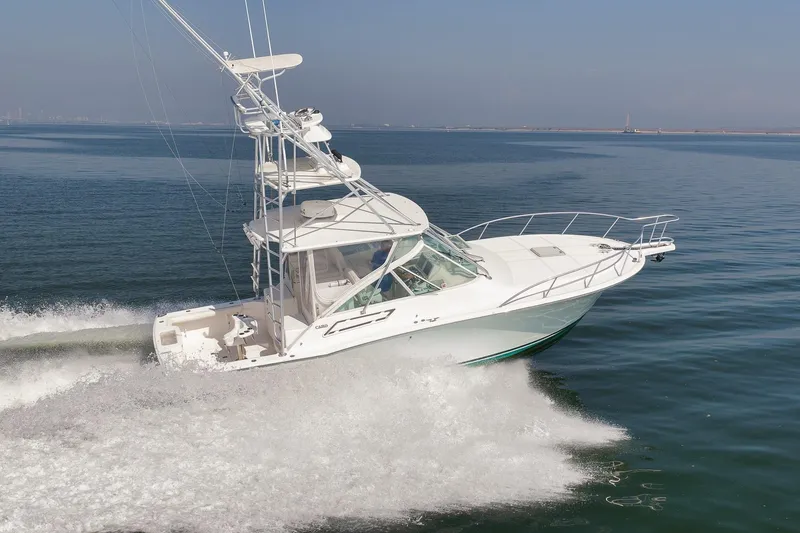 Slide: The Image of 2006 Cabo 32 Express yacht cruising on open water, creating a dynamic wake. - 7