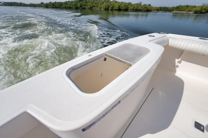 Slide: The Image of 2006 Cabo 32 Express boat interior with open storage compartment on calm water. - 25