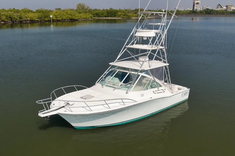 Slide: The Image of 2006 Cabo 32 Express boat on calm water, featuring a sleek design and tower. - 13