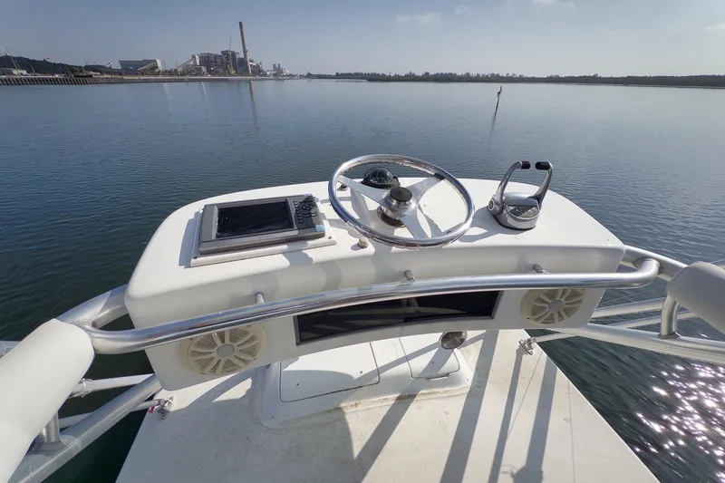 Slide: The Image of Helm of 2006 Cabo 32 Express boat with steering wheel and controls on calm water. - 26