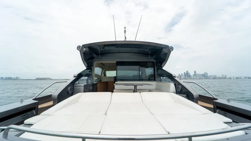 Slide: The Image of 2009 Pershing 64 yacht with spacious deck, city skyline in background. - 12