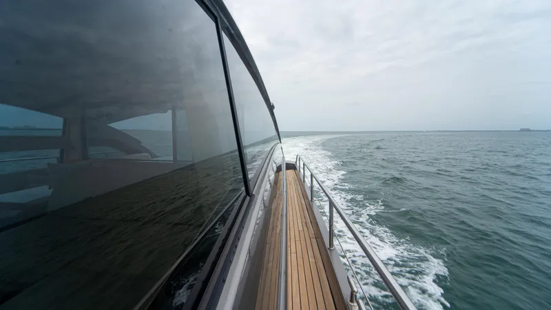 Slide: The Image of Side view of a 2009 Pershing 64 yacht cruising on open water. - 14
