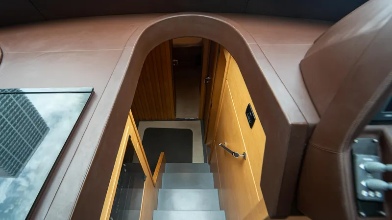 Slide: The Image of Interior view of 2009 Pershing 64 yacht, featuring a staircase and wooden paneling. - 26