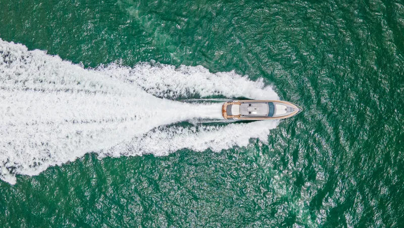 Slide: The Image of Aerial view of 2009 Pershing 64 yacht cruising on vibrant green ocean waters. - 8